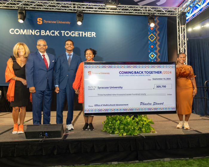 Ceremony participants on stage with check